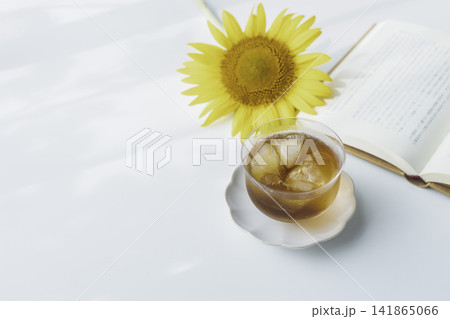 ひまわりと本を添えた冷たい麦茶、夏のくつろぎ時間 ひまわりと本を添えた冷たい麦茶、夏のくつろぎ時間 141865066