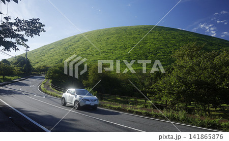 夏の大室山(伊豆高原)付近の道路と白いコンパクトSUV(ニッサン) 夏の大室山(伊豆高原)付近の道路と白いコンパクトSUV(ニッサン) 141865876