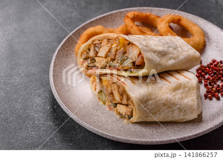 Grilled chicken shawarma or doner with tomatoes, cucumber, and sauces, takeout food 141866257