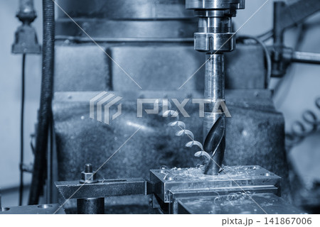 Hole making process on metal part using drill tool on milling machine in blue tone lighting 141867006