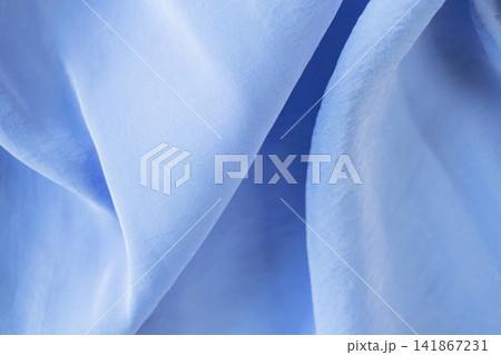 Blue silk fabric with soft folds and waves. Soft blue silk fabric background. Light satin textile, natural fabric. Blue silk fabric with soft folds and waves. Soft blue silk fabric background. Light satin textile, natural fabric. 141867231