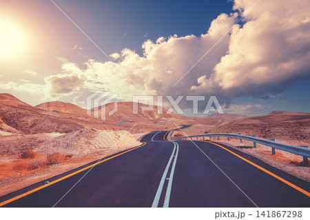 Driving a car on a mountain road. Desert landscape. The road from Arad to the Dead Sea. View from the car of the mountain landscape on a sunny day. Israel Driving a car on a mountain road. Desert landscape. The road from Arad to the Dead Sea. View from the car of the mountain landscape on a sunny day. Israel 141867298