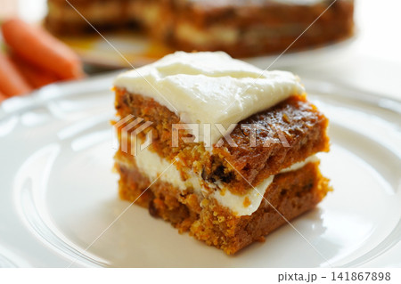 白い皿に乗ったクリームチーズフロスティングの手作りキャロットケーキ　クローズアップ 141867898