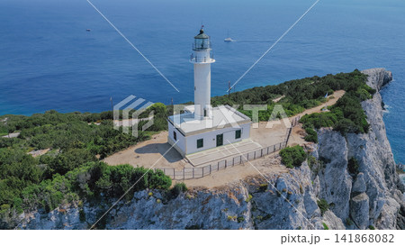Drone view of white lighthouse at Cape Lefkatas standing on dramatic white limestone cliff edge over Ionian sea in Lefkada Greece for travel destination backdrop Drone view of white lighthouse at Cape Lefkatas standing on dramatic white limestone cliff edge over Ionian sea in Lefkada Greece for travel destination backdrop 141868082