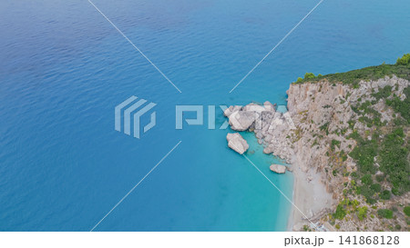 Aerial view of rocky coastline and cliffs at Kathisma beach with huge boulders in turquoise Ionian Sea water on Lefkada island Greece for summer nature background Aerial view of rocky coastline and cliffs at Kathisma beach with huge boulders in turquoise Ionian Sea water on Lefkada island Greece for summer nature background 141868128