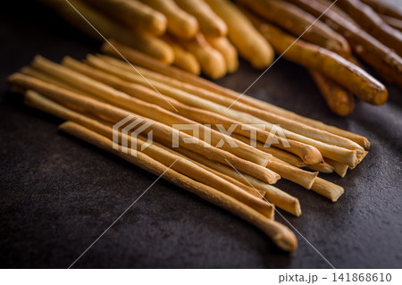 Assorted Breadsticks and Pretzel Sticks On Dark Surface - Grissini Snack Assortment for Entertaining Assorted Breadsticks and Pretzel Sticks On Dark Surface - Grissini Snack Assortment for Entertaining 141868610
