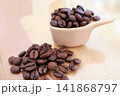 焙煎したコーヒー豆と計量スプーン 141868797