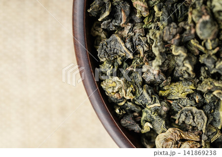 Macro overhead shot premium loose tea in wooden cup on linen like fabric Macro overhead shot premium loose tea in wooden cup on linen like fabric 141869238