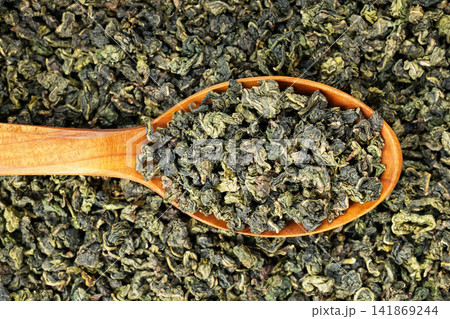 Green oolong tea scoop on flat background wooden spoon macro 141869244