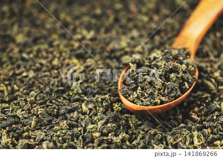 Tieguanyin loose leaf in wooden spoon on solid background Tieguanyin loose leaf in wooden spoon on solid background 141869266