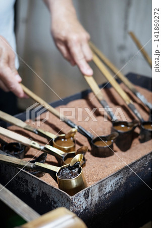 Rustic Turkish coffee ritual cezve brewing over heated sand 141869272
