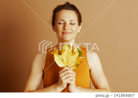 Serene Woman Embracing Autumn Leaves Serene Woman Embracing Autumn Leaves 141869807