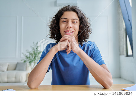 Smiling teen boy listening during online class Smiling teen boy listening during online class 141869824