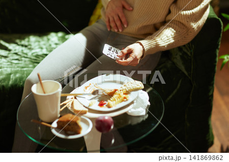Woman Feeling Unwell on Couch After Eating Fast Food Woman Feeling Unwell on Couch After Eating Fast Food 141869862