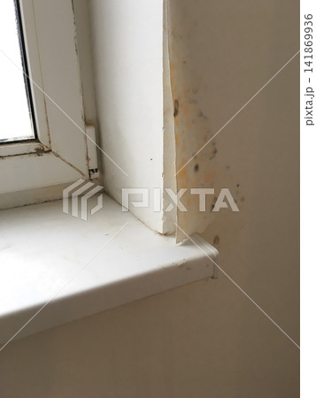 Close up of a white window frame with visible dirt and marks on the sill. 141869936