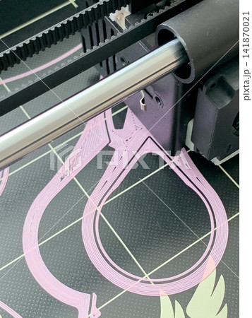 A close up view of a three d printer nozzle creating intricate pink plastic filament shapes A close up view of a three d printer nozzle creating intricate pink plastic filament shapes 141870021