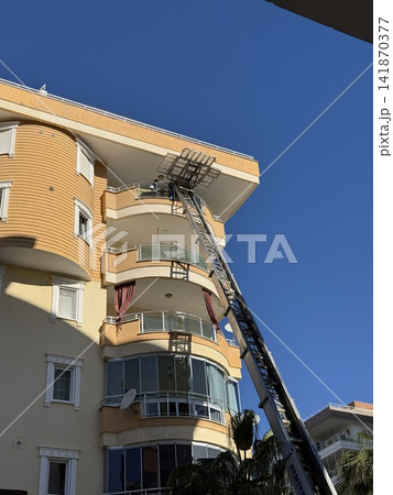 Building exterior with vibrant yellow facade and blue sky background seen from low angle Building exterior with vibrant yellow facade and blue sky background seen from low angle 141870377