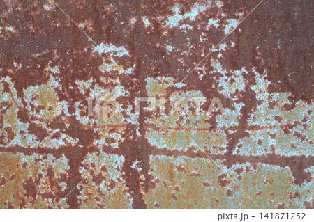 Iron sheet texture. Weathered and oxidized rusty iron sheet with peeling paint traces and horizontal seam. Industrial decay, aging 141871252