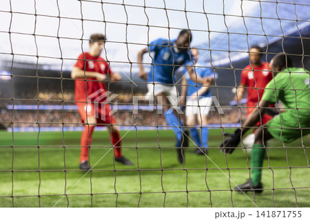 Blurred motion of player hitting ball in front of goalkeeper, player in motion attacking net to score goal. Goalie defending and blocking goal post by striker, football attack. Blurred motion of player hitting ball in front of goalkeeper, player in motion attacking net to score goal. Goalie defending and blocking goal post by striker, football attack. 141871755