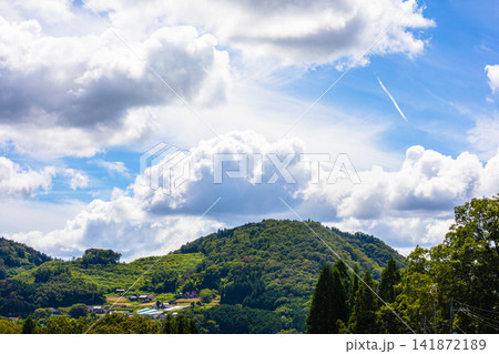 ひこうき雲と湧き立つ夏雲が広がる青空 ひこうき雲と湧き立つ夏雲が広がる青空 141872189