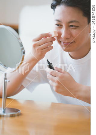 BBクリームのチューブを持つ40代男性 141874859