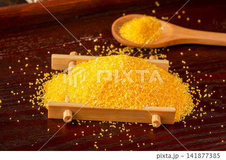 fine yellow corn grits pile with a wooden spoon fine yellow corn grits pile with a wooden spoon 141877385