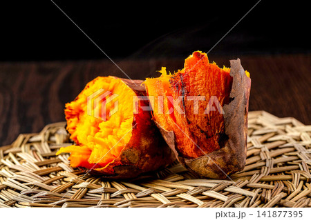 whole Roasted Sweet Potato Cut Open Showing Orange Flesh 141877395