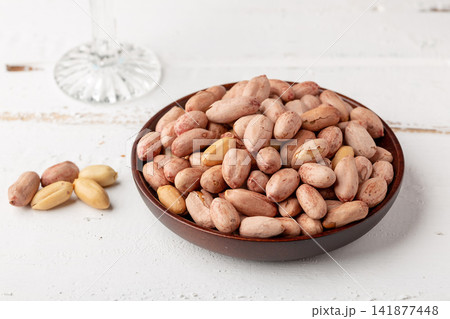 roasted salted peanuts with skin served on small dish 141877448