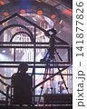 Backstage view of cameraman filming live event on stage under stadium lights with copy space 141877826