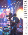 Steadicam operator filming live performance on stage with camera stabilizer and copy space 141877828