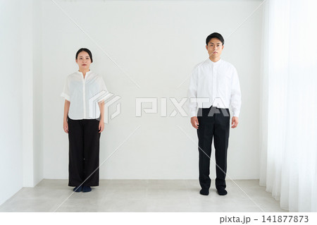 白い壁の前に並ぶ若い男女 141877873