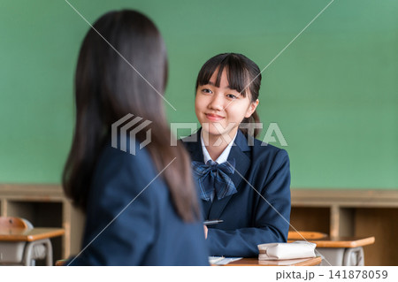 学校の教室で会話する中学生の女子生徒 141878059