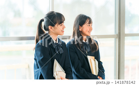 学校の教室で会話する小学生,中学生の女子生徒 学校の教室で会話する小学生,中学生の女子生徒 141878142