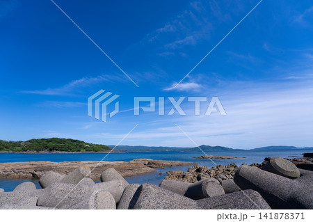 鮮やかな青空と穏やかな海に沿って並ぶコンクリート消波ブロック 鮮やかな青空と穏やかな海に沿って並ぶコンクリート消波ブロック 141878371