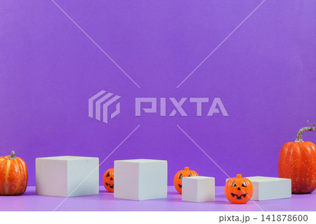 Halloween product display mockup with white podiums jack-o-lanterns and pumpkins on purple background Halloween product display mockup with white podiums jack-o-lanterns and pumpkins on purple background 141878600