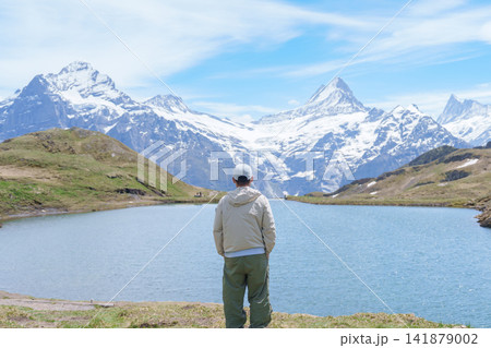 man Tourist Explore Grindelwald First, Switzerland in Summer. Hiker visit Bachalpsee Lake and Swiss Alps in Jungfrau Region. Famous Traveler Attraction, Travel Destination and hiking trail in Europe man Tourist Explore Grindelwald First, Switzerland in Summer. Hiker visit Bachalpsee Lake and Swiss Alps in Jungfrau Region. Famous Traveler Attraction, Travel Destination and hiking trail in Europe 141879002