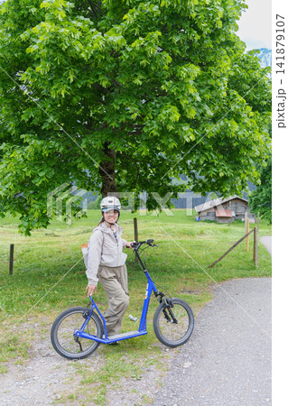 Woman Tourist Riding First Trottibike from Bort to Grindelwald, Switzerland in Summer. Scenic Alpine Meadows, Farmhouses, Adventure Activity, Famous Travel Destination in Europe. Top of Adventure 141879107