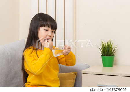 Asian girl taking medicine with water sick child healthcare treatment concept 141879692