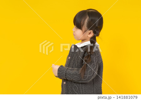 Stubborn little girl turning away and looking back with a grumpy side profile expression. 141881079