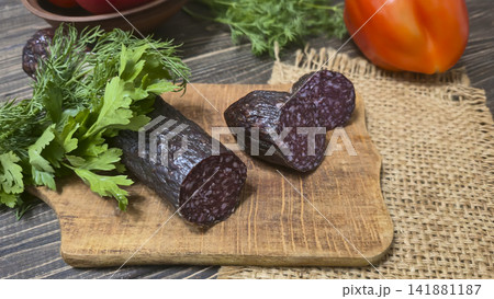 Traditional smoked sausage with fresh dill and tomatoes on a rustic wooden table. Traditional smoked sausage with fresh dill and tomatoes on a rustic wooden table. 141881187