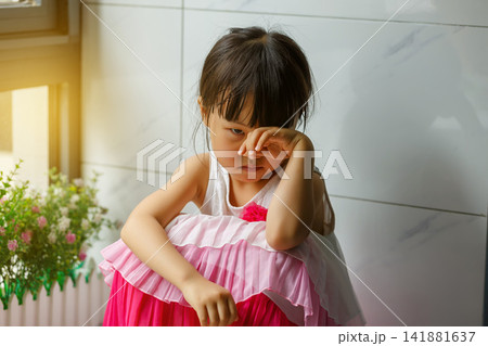 Sad and lonely little girl sitting on the floor in the corner looking depressed Sad and lonely little girl sitting on the floor in the corner looking depressed 141881637