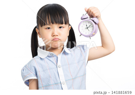 Frustrated child holding alarm clock showing time management pressure 141881659