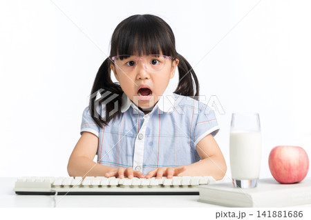 Surprised girl with open mouth using computer keyboard on desk 141881686