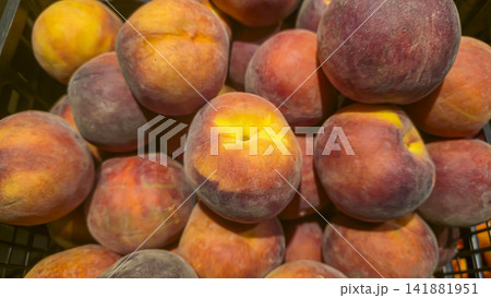 Ripe nectarines and peaches are displayed in plastic shopping crates. Ripe nectarines and peaches are displayed in plastic shopping crates. 141881951