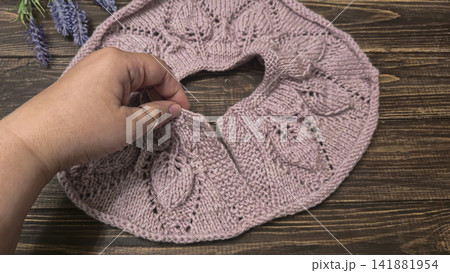 Knitted sweater collar in progress, using knitting needles and stitch markers. 141881954