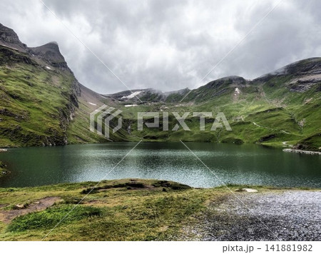 スイス・アルプスの山々に囲まれた静寂に包まれる澄んだ山上の湖風景 スイス・アルプスの山々に囲まれた静寂に包まれる澄んだ山上の湖風景 141881982