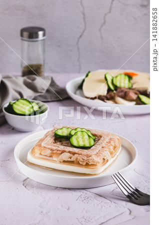 Delicious jellied chicken with mayonnaise on a plate on the table vertical view Delicious jellied chicken with mayonnaise on a plate on the table vertical view 141882658