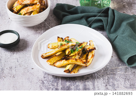 Vegetarian fried zucchini strips with herbs on a plate on the table 141882693