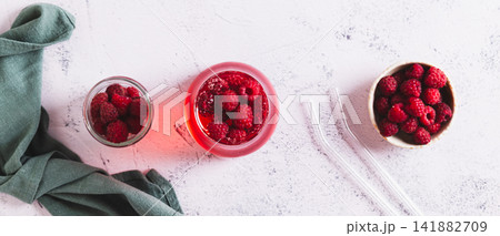 Raspberry drink in a frosted glass on the table top view web banner 141882709