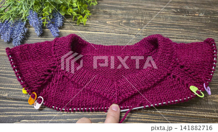 Knitted sweater collar in progress, using knitting needles and stitch markers. Knitted sweater collar in progress, using knitting needles and stitch markers. 141882716